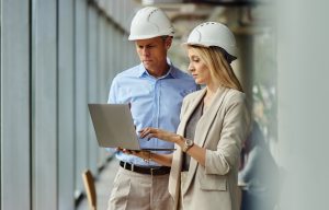 Construction professionals reviewing project information on a laptop
